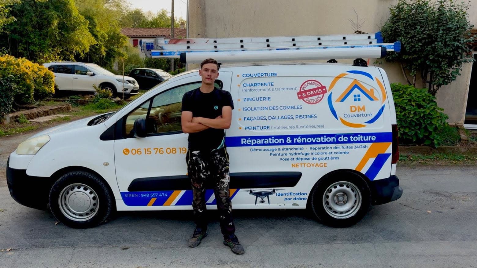 Artisan couvreur posant devant son véhicule de service DM Couverture avec une échelle de toit.